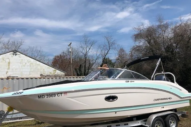 Slide: The Image of 2019 Chaparral 250 Suncoast boat on trailer, parked outdoors under a cloudy sky. - 6