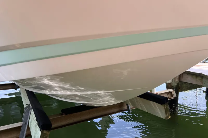 Slide: The Image of 2019 Chaparral 250 Suncoast boat hull on lift over water. - 7