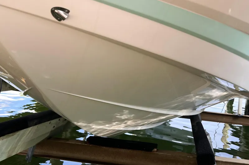 Slide: The Image of 2019 Chaparral 250 Suncoast boat hull on lift, reflecting water below. - 9