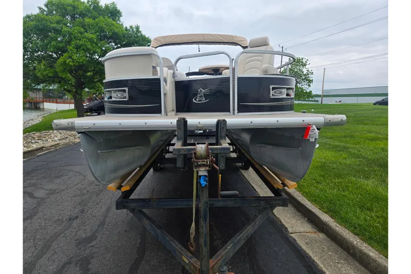 Slide: The Image of 2012 Misty Harbor 2285 Biscayne Bay RL pontoon boat on trailer, parked near grassy area. - 6