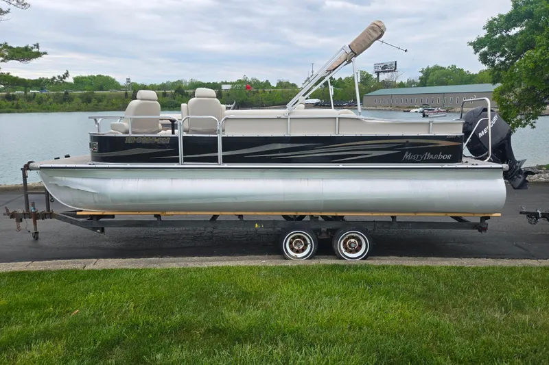 Slide: The Image of 2012 Misty Harbor 2285 Biscayne Bay RL pontoon boat on trailer by a lake. - 9