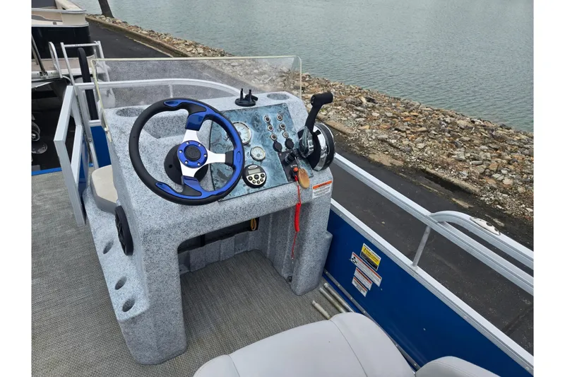 Slide: The Image of Steering console of a 2021 Lexington 315 boat, featuring controls and a blue-accented wheel. - 19