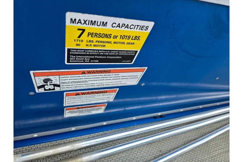 Slide: The Image of 2021 Lexington 315 boat capacity and safety warning labels on blue surface. - 20