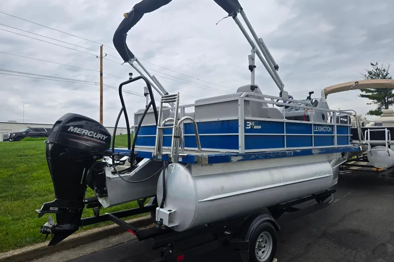 Slide: The Image of 2021 Lexington 315 pontoon boat with Mercury outboard motor on trailer. - 3