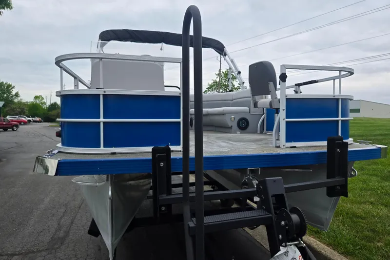 Slide: The Image of 2021 Lexington 315 pontoon boat on trailer, featuring blue and silver design. - 6