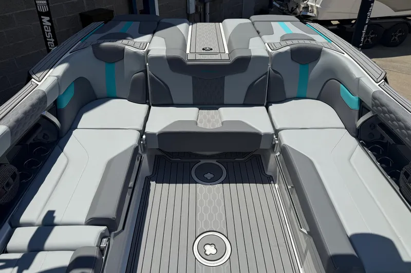 Slide: The Image of 2025 MasterCraft XT24 boat interior with sleek gray and teal seating design. - 10