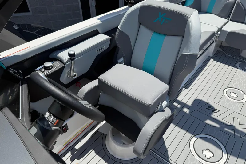 Slide: The Image of 2025 MasterCraft XT24 boat interior with steering wheel and modern seating design. - 12