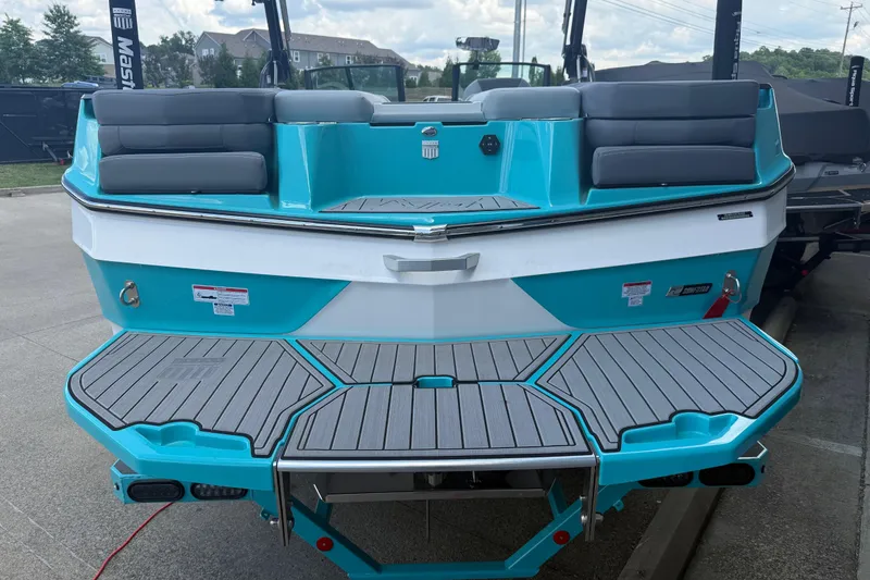 Slide: The Image of 2025 MasterCraft XT24 boat with turquoise and gray seating, rear view. - 23