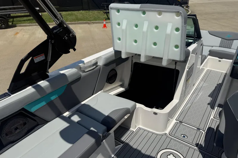 Slide: The Image of 2025 MasterCraft XT24 boat interior with open storage compartment and sleek seating design. - 5