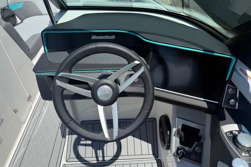 Slide: The Image of 2025 MasterCraft XT24 boat dashboard with modern steering wheel and digital display. - 7
