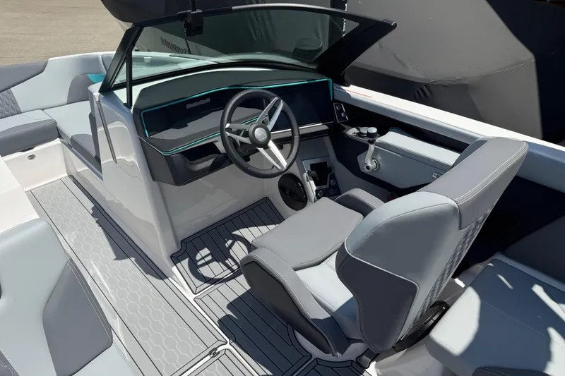 Slide: The Image of 2025 MasterCraft XT24 boat interior with sleek steering wheel and modern seating design. - 8