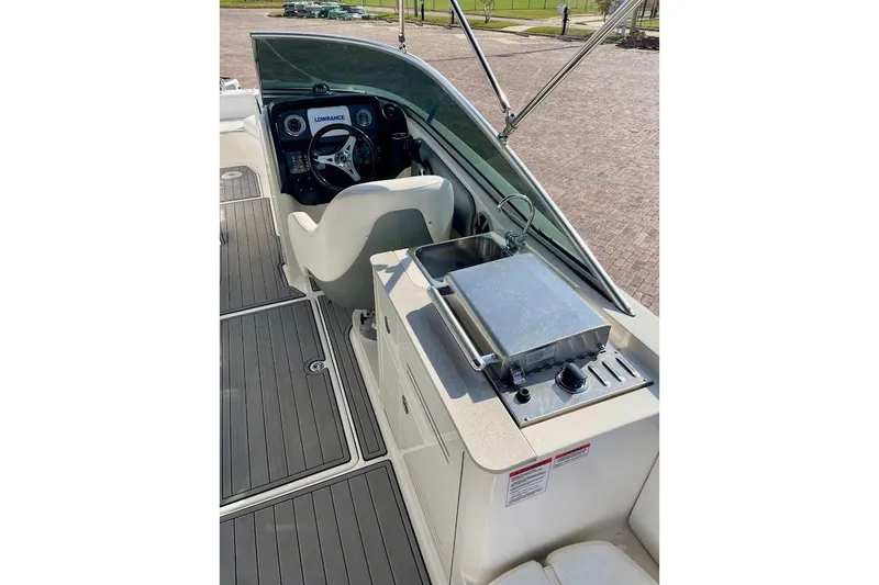 Slide: The Image of 2010 Sea Ray 300 Sundeck interior with helm, sink, and grill on deck. - 17