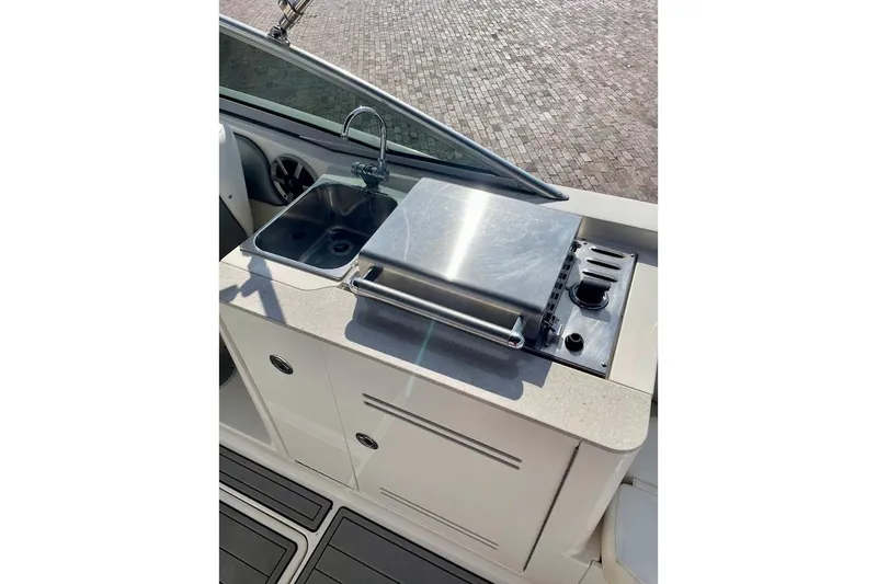 Slide: The Image of 2010 Sea Ray 300 Sundeck boat kitchenette with sink and grill. - 18
