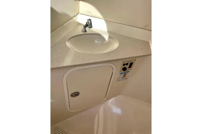 Slide: The Image of 2010 Sea Ray 300 Sundeck interior sink with faucet and storage compartment. - 20