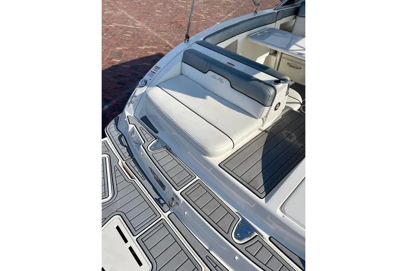 Slide: The Image of 2010 Sea Ray 300 Sundeck boat with cushioned seating and sleek deck design. - 22