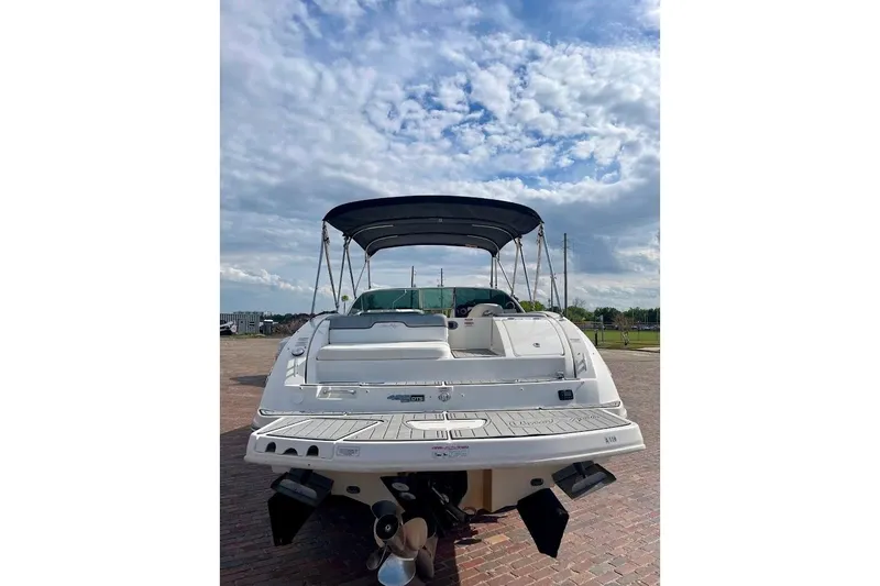 Slide: The Image of 2010 Sea Ray 300 Sundeck boat with canopy, viewed from the rear under a cloudy sky. - 4