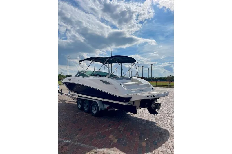 Slide: The Image of 2010 Sea Ray 300 Sundeck boat on trailer under cloudy sky. - 5
