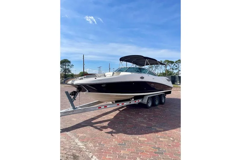 Slide: The Image of 2010 Sea Ray 300 Sundeck boat on trailer under clear blue sky. - 6