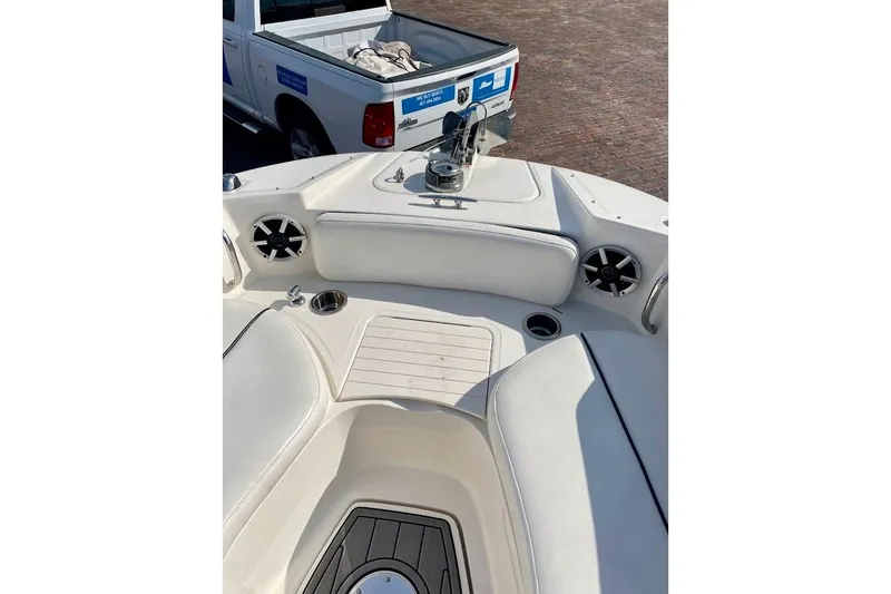 Slide: The Image of 2010 Sea Ray 300 Sundeck interior with white seating and cup holders, parked near a truck. - 9