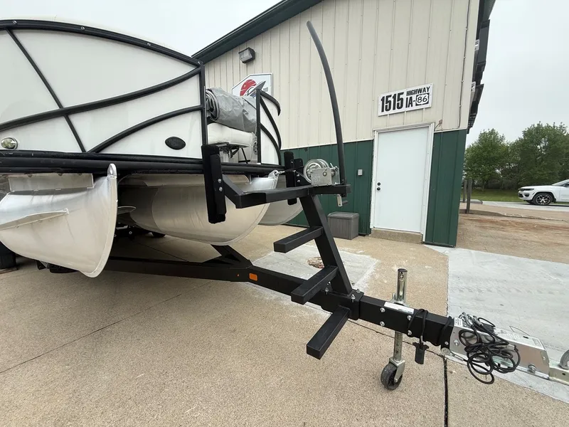 Slide: The Image of 2017 South Bay 500 Series pontoon boat on trailer in front of building. - 29