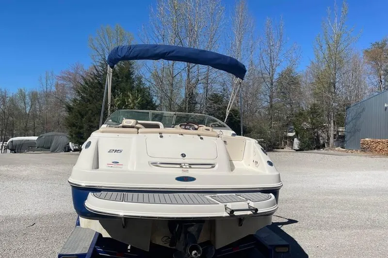 Slide: The Image of 2007 Chaparral 215 SSi boat with blue canopy, parked outdoors on a sunny day. - 3