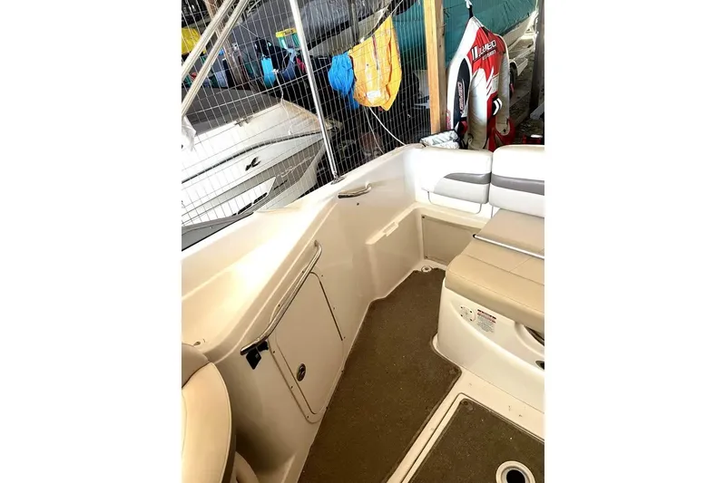 Slide: The Image of 2007 Chaparral 215 SSi boat interior with beige seating and storage compartments. - 7