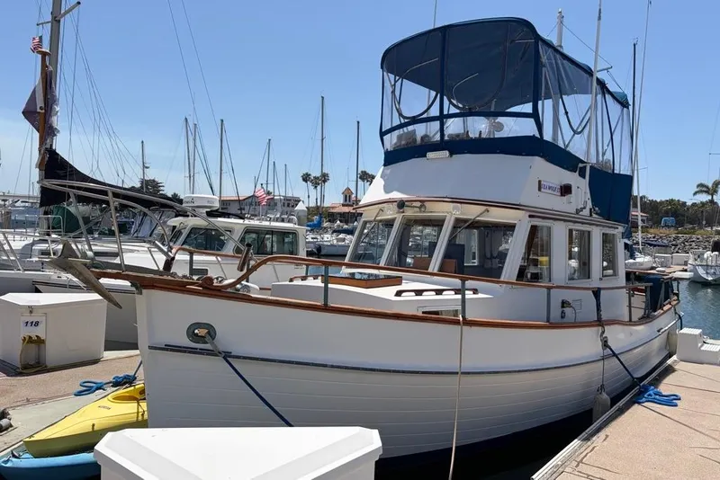 The Image of 1976 Grand Banks 32 Sedan boat docked at a marina under clear skies. - 0