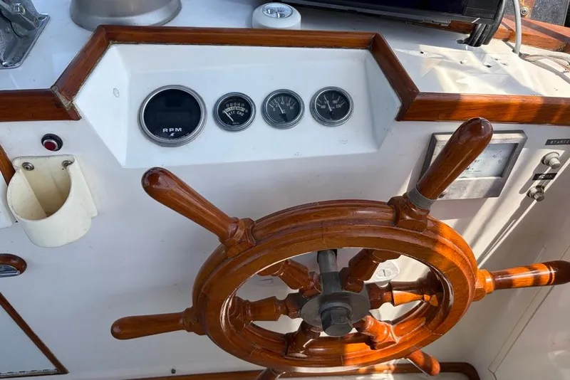 Slide: The Image of Wooden steering wheel and gauges on a 1976 Grand Banks 32 Sedan boat. - 11