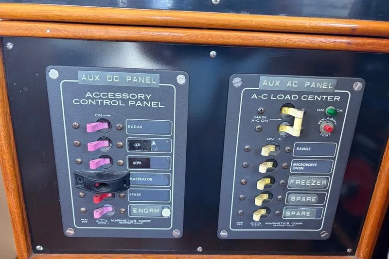 Slide: The Image of Control panels on a 1976 Grand Banks 32 Sedan boat, featuring AC and DC switches. - 14