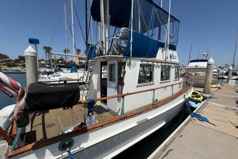 Slide: The Image of 1976 Grand Banks 32 Sedan docked at a marina under clear blue skies. - 2
