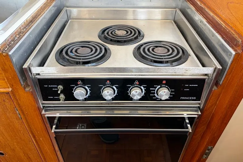 Slide: The Image of Electric stove with three burners in a 1976 Grand Banks 32 Sedan boat kitchen. - 28
