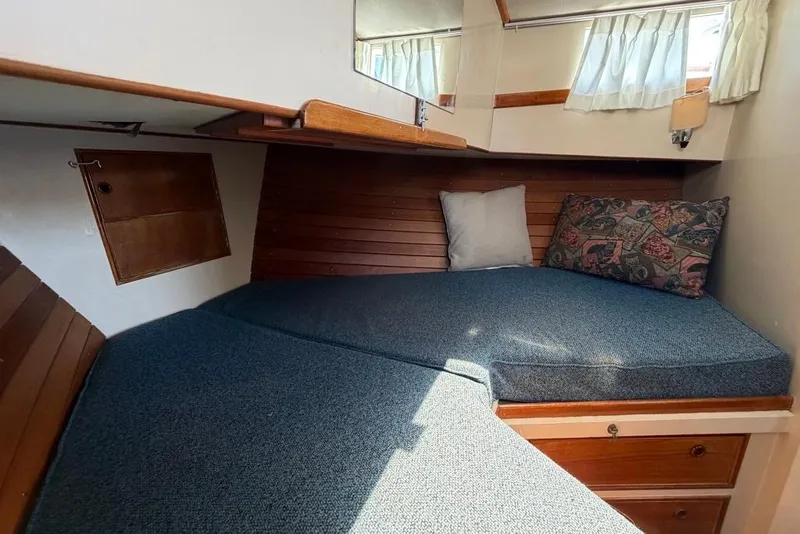 Slide: The Image of 1976 Grand Banks 32 Sedan cabin interior with cozy bedding and wooden accents. - 29