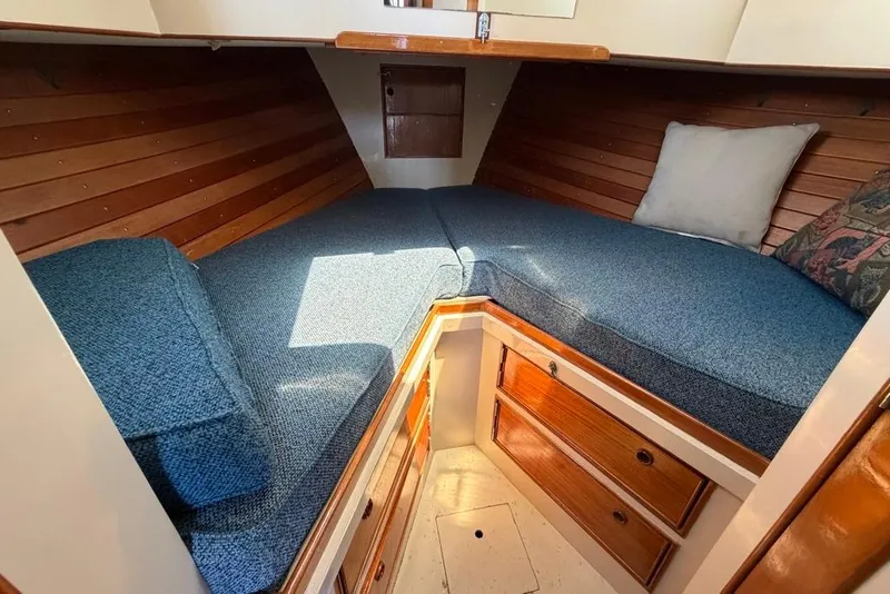 Slide: The Image of Cozy cabin interior of 1976 Grand Banks 32 Sedan with blue cushions and wooden accents. - 30