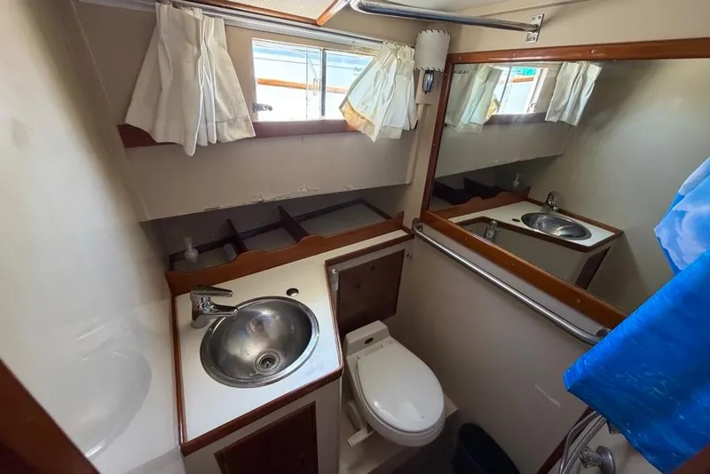 Slide: The Image of Bathroom interior of a 1976 Grand Banks 32 Sedan boat, featuring sink and toilet. - 35