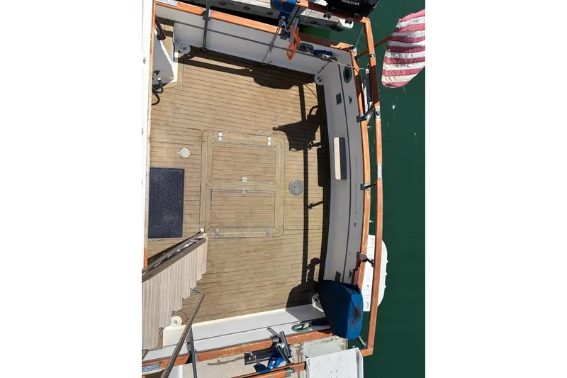 Slide: The Image of 1976 Grand Banks 32 Sedan boat deck with wooden flooring and American flag. - 6