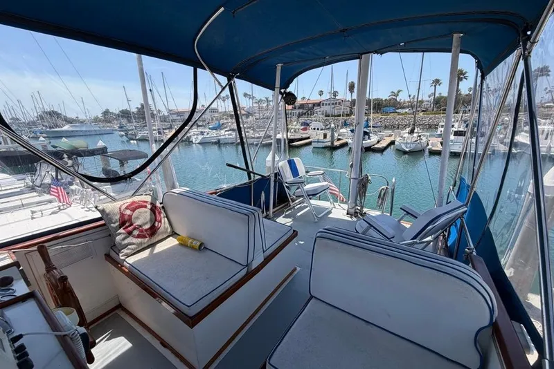 Slide: The Image of 1976 Grand Banks 32 Sedan interior with marina view, featuring seating and nautical decor. - 8