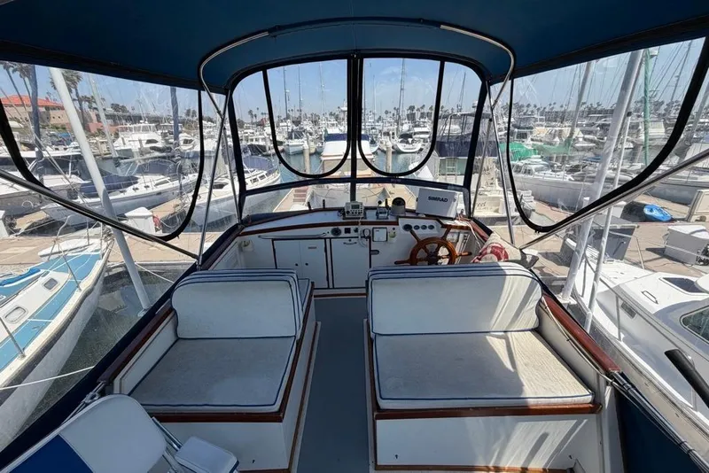 Slide: The Image of Interior view of 1976 Grand Banks 32 Sedan yacht at marina, showcasing helm and seating area. - 9