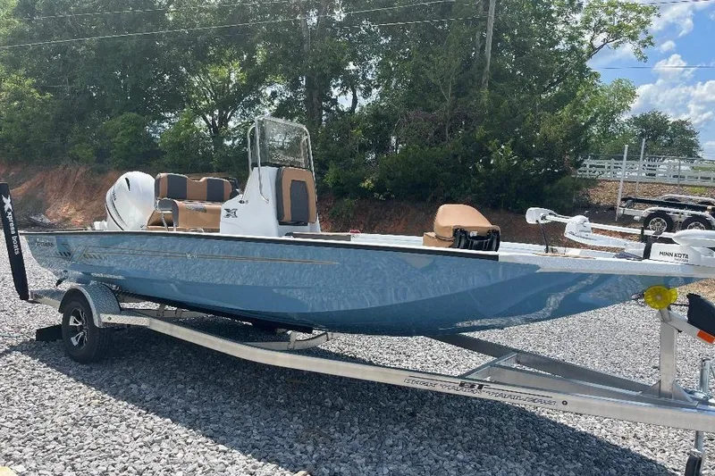 The Image of 2026 Xpress H20B Bay boat on trailer, parked outdoors on gravel. - 1