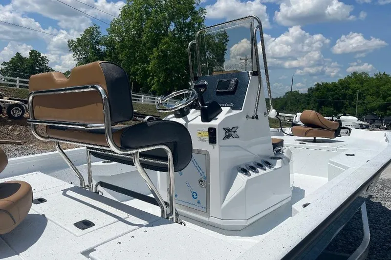 Slide: The Image of 2026 Xpress H20B Bay boat interior with steering console and seating under blue sky. - 4
