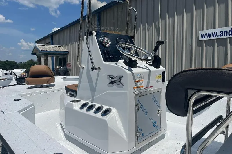 Slide: The Image of 2026 Xpress H20B Bay boat console with steering wheel, docked near a building. - 6