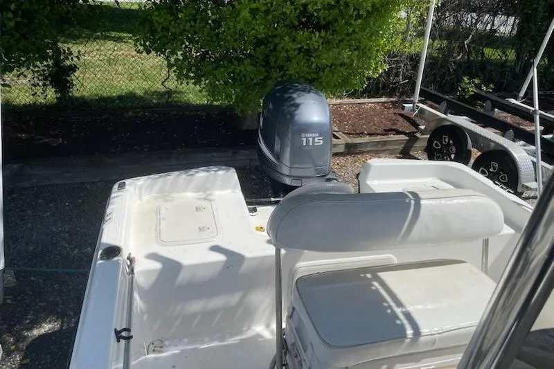 Slide: The Image of 2004 Century 1901 Bay Boat with Yamaha 115 engine, parked near greenery. - 16