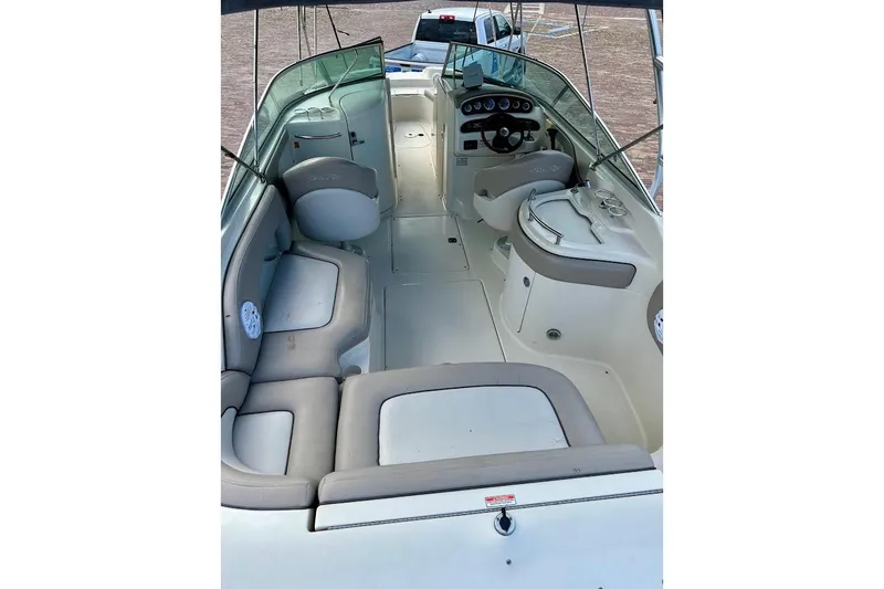 Slide: The Image of 2004 Sea Ray 270 Sundeck interior with spacious seating and helm, showcasing luxury design. - 18