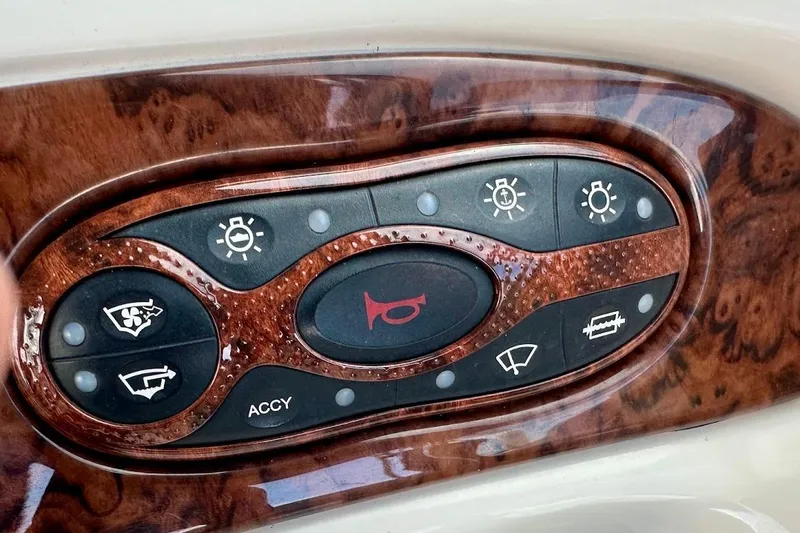 Slide: The Image of Dashboard controls of a 2004 Sea Ray 270 Sundeck boat with woodgrain finish. - 33