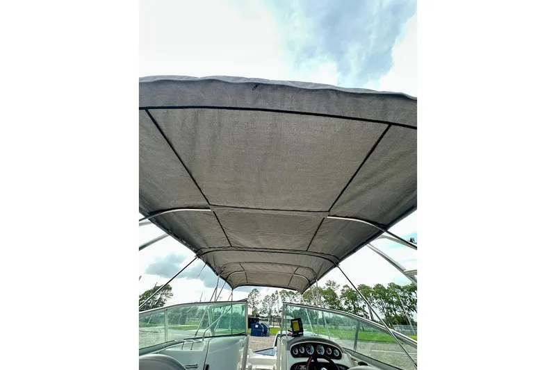 Slide: The Image of 2004 Sea Ray 270 Sundeck boat with canopy, dashboard view, under cloudy sky. - 42