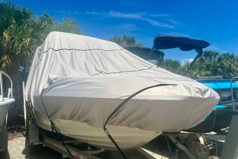 Slide: The Image of Covered 2004 Sea Ray 270 Sundeck boat on trailer, surrounded by palm trees. - 45