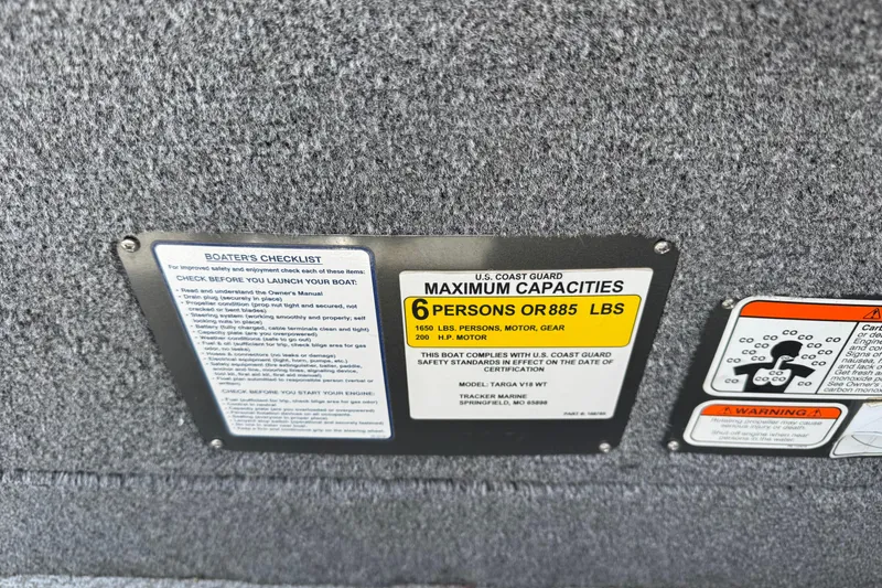 Slide: The Image of 2019 Tracker Targa V-18 WT capacity label, 6 persons or 885 lbs, safety checklist. - 9