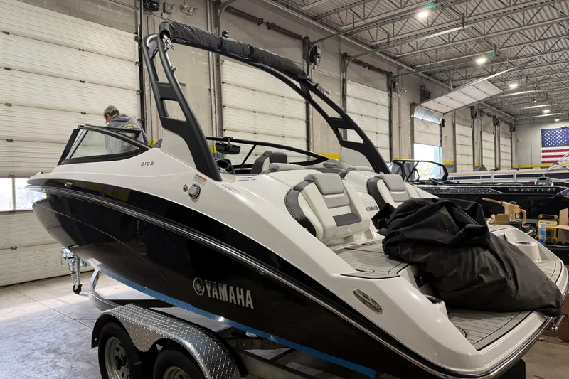 The Image of 2021 Yamaha Boats 212S in a showroom, featuring sleek design and modern seating. - 0