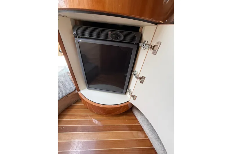 Slide: The Image of Compact refrigerator inside a 2004 Cobalt 360 boat, with wooden flooring and cabinetry. - 15