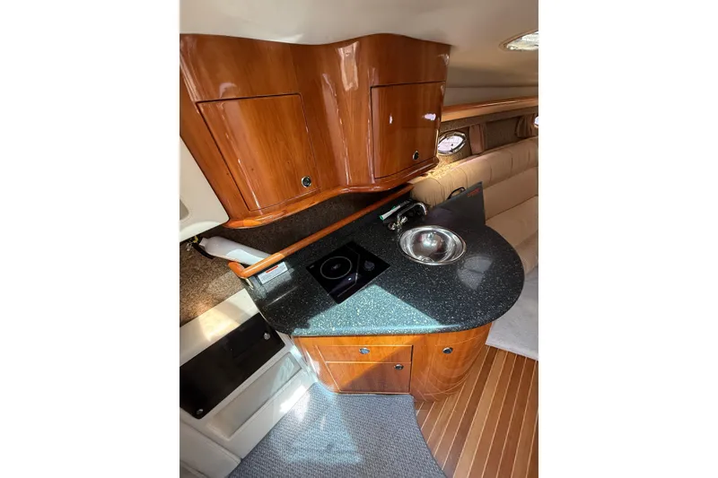 Slide: The Image of Luxurious 2004 Cobalt 360 yacht interior with sleek wooden cabinetry and modern kitchenette. - 16