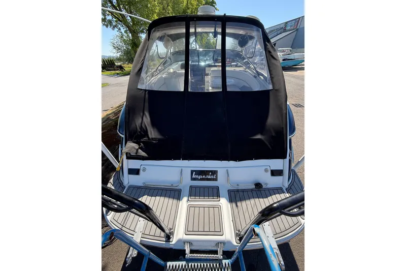 Slide: The Image of 2004 Cobalt 360 boat with black cover, docked outdoors on a sunny day. - 20